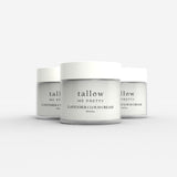 Three jars of Tallow Me Pretty Lavender Cloud Cream are lined up in a row. Each jar is sleek and modern, with a minimalist design featuring the product name and brand in a simple, elegant font against a translucent cream backdrop that softly diffuses the light.