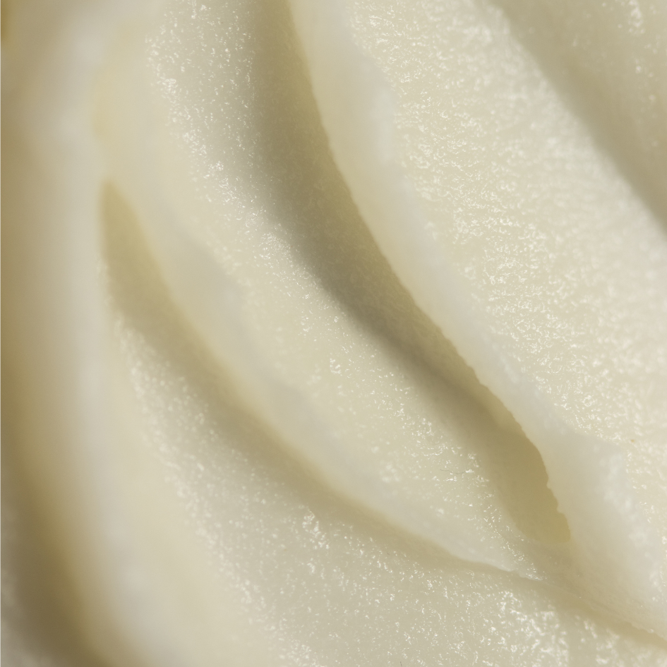 Macro close-up of a creamy white Tallow and Honey Balm, showcasing the product's whipped, smooth texture with peaks and valleys that glisten subtly in the light, reflecting the rich, natural ingredients designed for skin nourishment and protection.