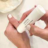 Hands applying Tallow Me Pretty Gentle Balm from a convenient stick applicator, demonstrating the ease of use for soothing and nourishing sensitive skin on the go.